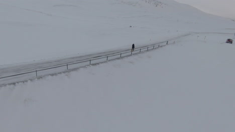 Orbit-view-around-girl-walking-on-frozen-road-in-countryside