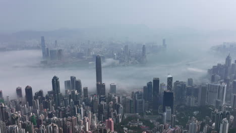 Timelapse-slow-pulling-away-of-fog-covered-Hong-Kong-city-skyline-and-Victoria-Harbour