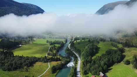 Drone-footage-of-Stryn-river,-clouds-over-it-and-a-road-along-the-river