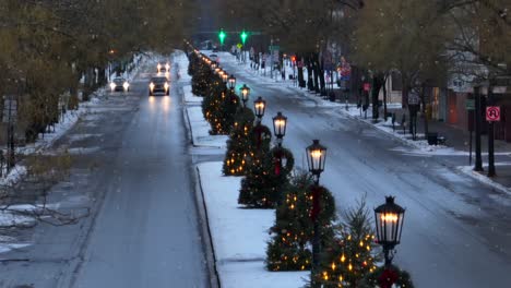Long-aerial-zoom-of-Christmas-trees-lining-famous-main-street-in-Wellsboro,-PA