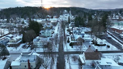 Aerial-dolly-forward-of-snow-falling-on-quaint-small-town-in-America