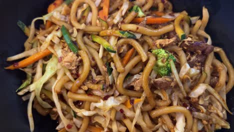 Delicious-spicy-chicken-and-beef-udon-noodles-with-vegetables,-wok-fried-noodles,-Asian-cuisine,-4K-shot