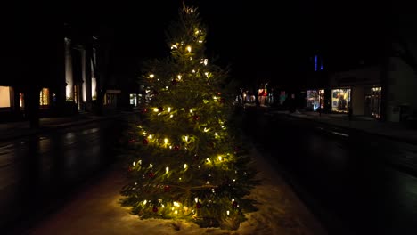 Slow-aerial-orbit-around-Christmas-tree-with-lights-on-main-street-of-Wellsboro-Pennsylvania