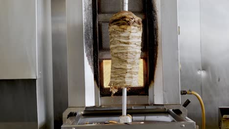 Big-Chicken-Shawarma-Skewer-Hanged-On-Grill-Turning-Around-On-Fire