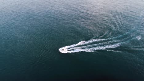 Drone-view-of-boat-sailing-to-the-left-on-open-ocean-on-a-warm-sunny-summer-day-in-the-Faroe-Islands