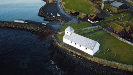 Drohnen-Sonnenuntergang-Orbitaufnahme-Der-Kirche-Im-Dorf-Kirkjubour-Mit-Meerblick-Auf-Den-Färöer-Inseln-An-Einem-Sonnigen-Sommertag