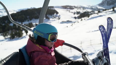 Happy-little-girl-waving-at-father-riding-ski-lift-above-snowy-resort