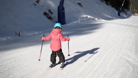 Child-learning-to-ski-on-snowy-sunlit-Andorra-Pyrenees-mountain-resort-skiing-track