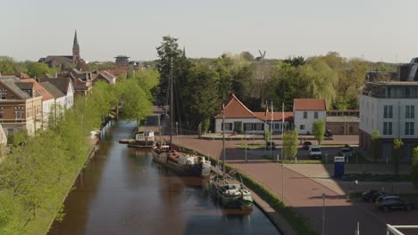 Canal-with-historical-buildings-and-boats-in-north-germany-in-Papenburg-drone-shot