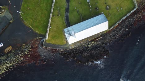Drone-sunset-shot-from-above-of-church-in-Kirkjubour-village-in-the-Faroe-islands-on-sunny-summer-day