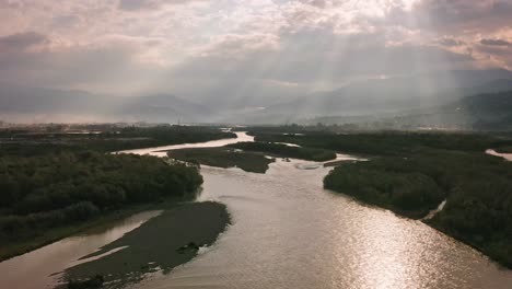 Aerial-view-of-river-estuary-and-woodland-valley-under-dramatic-cloudscape-nearby-Batumi-city,-Georgia