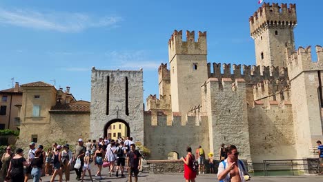 Hundreds-of-tourists-arrive-at-Scaliger-Castle-in-Sirmone,-Italy