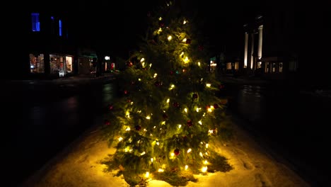 Slow-cinematic-rising-aerial-shot-of-lit-Christmas-tree-with-lights-at-night