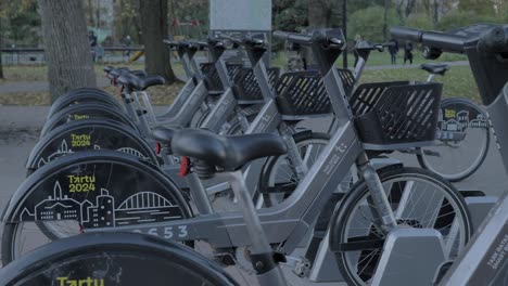 Tartu-2024-electric-bikes-in-charging-dock,-Rental-bikes-for-green-environment