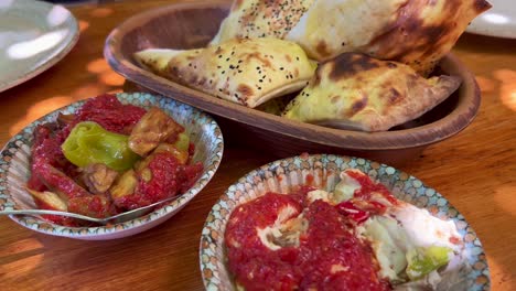 Traditional-Turkish-Meze-dishes-with-fresh-pide-ekmek-bread-in-Bodrum-Turkey,-authentic-tasty-eggplant-starters,-4K-shot