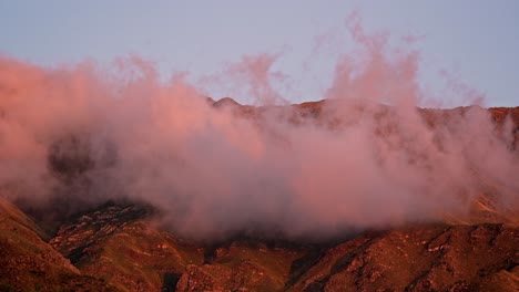 Vista-Dramática-Y-épica-De-Un-Lapso-De-Tiempo-De-Montaña-Con-Nubes-Naranjas-Al-Atardecer-En-Merlo,-San-Luis-En-Argentina