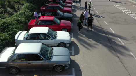 Aerial-view-BMW-series-e30-classic-car-show-fan-club-meeting-over-row-of-parked-cars