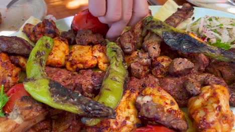 Traditional-Turkish-big-meat-platter-mixed-grill-with-vegetables-and-fresh-pide-ekmek-bread-in-Bodrum-Turkey,-authentic-tasty-food,-4K-shot