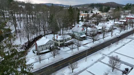 Aerial-reveal-of-snowy-neighborhood-in-America-from-behind-pine-tree