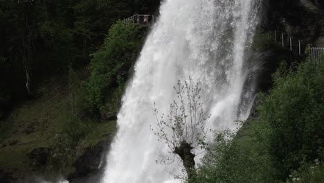 Aerial-tilt-down-shot-of-crashing-waterfall-in-slow-Motion-at-wilderness-of-Norway