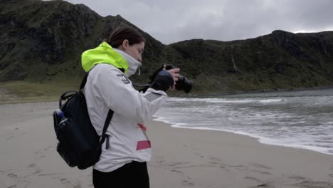 Female-Photographer-taking-pictures-of-beautiful-mountains-and-ocean-during-cloudy-day