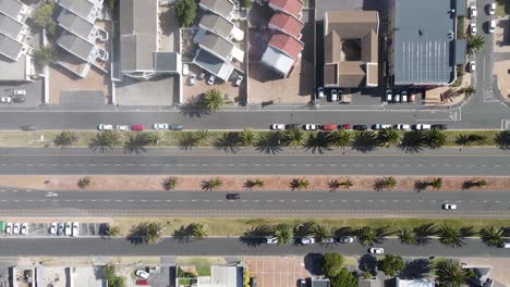 Top-view-of-a-tropical-looking-highway-with-some-traffic-and-palm-trees-on-the-side