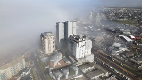 Bloubergstrand-center-buildings-blocking-the-incoming-fog-from-the-ocean-with-morning-traffic-on-the-streets
