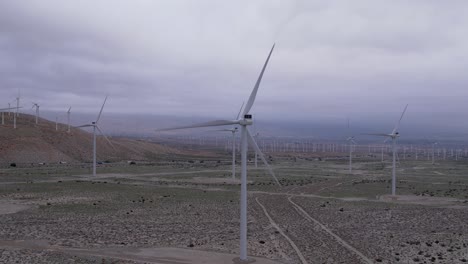 Aerial-footage-of-a-wind-farm-in-the-Palm-Springs-desert-on-a-cloudy-day,-slow-zoom-in-and-out-pan-shot
