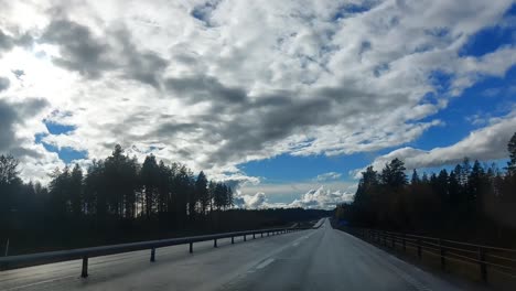Driving-on-a-Swedish-highway-under-beautiful-cloudscape