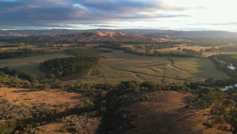 Aerial-footage-across-the-hills-lit-by-early-morning-light-near-the-Goulburn-River-in-Victoria-Australia