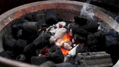 glowing-coal-with-rising-smoke-in-fireplace-close-up