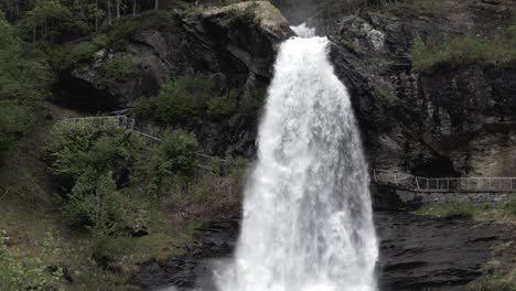 Tilt-up-shot-waterfall-crashing-down-in-forest-in-Norway---Steindalsfossen-Waterfall