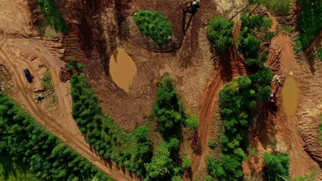 Aerial-shot-of-heavy-machinery-in-nature-digging-around-a-forest