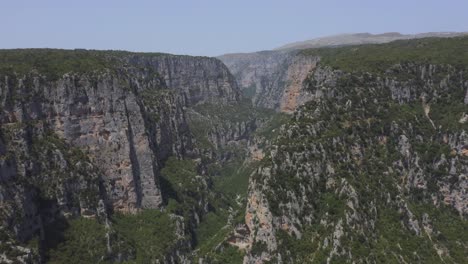 An-aerial-view-past-the-Vikos-gorge-canyon-in-Epirus,-Greece-with-clear-skies