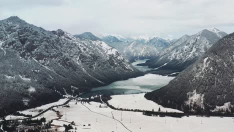 Luftdrohnenansicht-Der-Majestätischen-Schneebedeckten-österreichischen-Alpen,-Straßen-Und-Flüsse,-Die-Sich-Durch-Die-Landschaft-Schlängeln