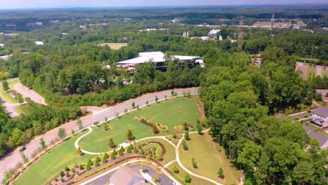 Aerial-drone-shot-tilting-up-from-a-small-neighborhood-to-look-out-over-the-city-of-Alpharetta,-GA-and-the-Ameris-Bank-Amphitheater