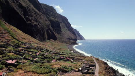 Aerial-view-of-remote-village-on-epic-cliff-coast-with-blue-ocean,-Madeira
