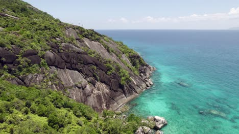 Drone-over-national-park,-anse-major-nature-trail,-and-marine-park,-rock-boulders-blue-turquoise-water