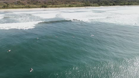 Aerial-view-of-a-crowded-beach-full-of-surfers-in-Nosara,-Costa-Rica
