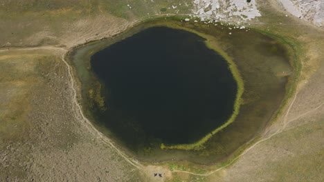 Eine-Luftaufnahme-Eines-Hohen-Bergsees-In-Tymfi,-Griechenland,-In-Einer-Kreisförmigen-Augenähnlichen-Form