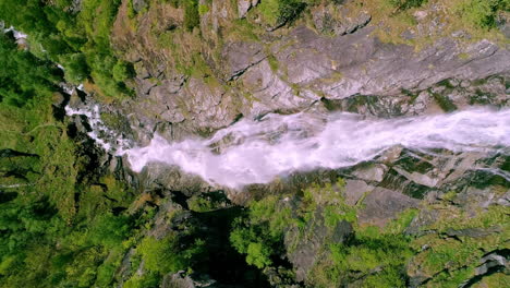 Amazing-slow-motion-aerial-of-a-waterfall-in-green-lush-mountains-in-the-soft-dayligt