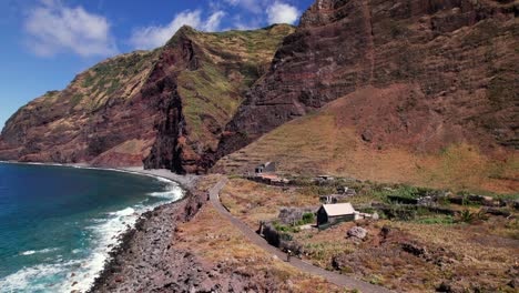 Aerial-view-of-tourist-woman-walking-on-volcanic-red-coast,-Madeira