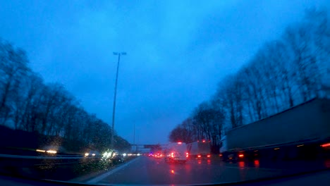 Driver-driving-car-in-the-rain-on-busy-highway-at-evening-with-wipers---POV-hyperlapse