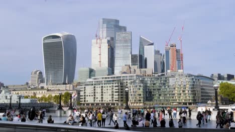Gente-Caminando-Con-Vistas-A-Los-Rascacielos-De-La-Ciudad-De-Londres-Y-Modernos-Edificios-De-Oficinas-En-Un-Día-Soleado-Con-Cielos-Despejados
