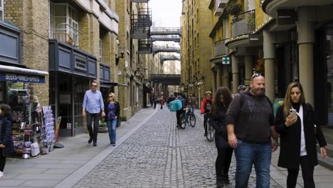 London-Shad-Thames-cobblestone-street-with-people-and-bicycles-in-slow-motion