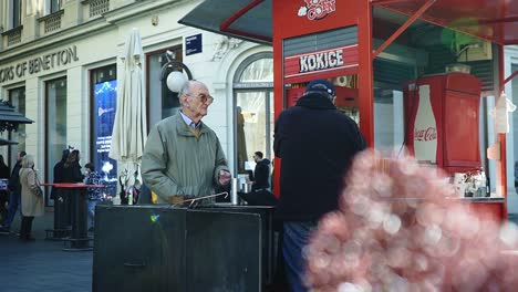 Senior-man-buying-some-popcorn-at-a-stand-in-central-Zagreb,-Croatia