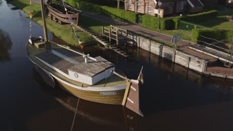 Historical-ship-in-the-middle-of-a-canal-in-the-north-of-Germany-in-Papenburg-Droneshot