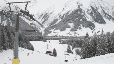 Panoramic-view-of-operational-cable-car-ski-lift-set-against-majestic-snow-covered-mountains-in-Austrian-alps
