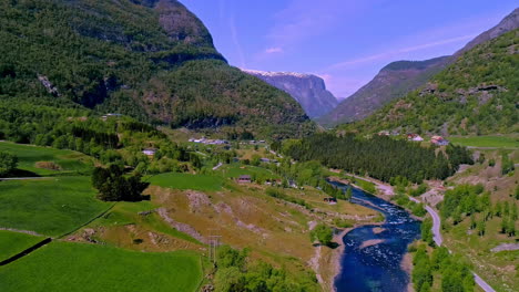Deep-blue-river-flow-through-green-forestry-mountains-valley,-aerial-view