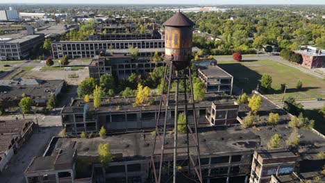 Rusty-water-tower-and-Old-Packard-Plant-in-Detroit,-aerial-drone-view